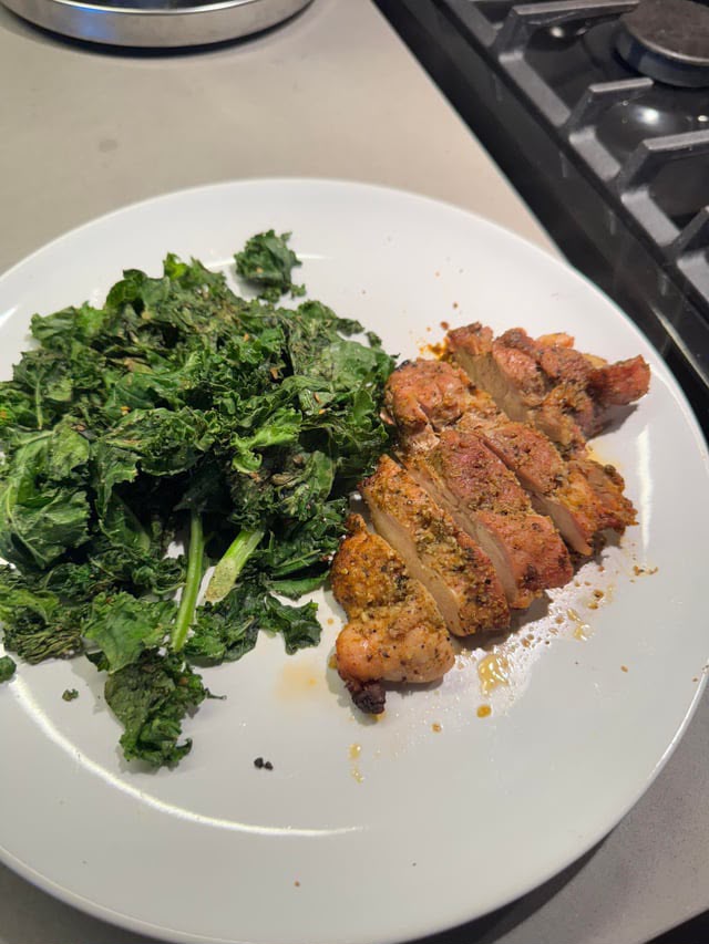 Plato con cerdo grillado en fetas y kale salteado
