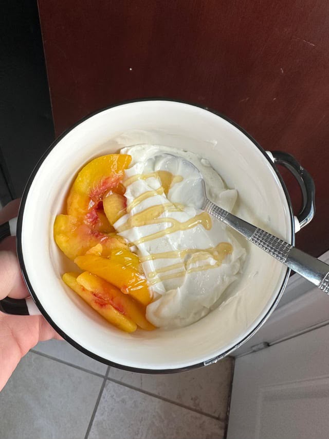 Bowl con yogur griego, melocotones frescos y miel de abeja